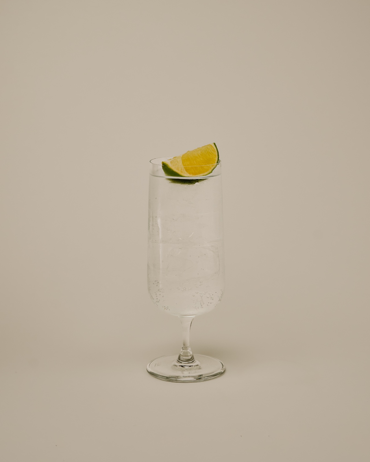 Clear highball serve with a lime wedge